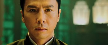 Movie still from “Ip Man 2” (2010), directed by Wilson Yip – A man's face in a suit and tie; Close Up shot, Low angle