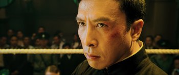 Movie still from “Ip Man 2” (2010), directed by Wilson Yip – A person with a boxing ring in the background; Close Up shot, High angle
