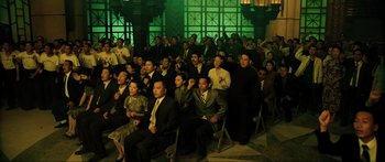 Movie still from “Ip Man 2” (2010), directed by Wilson Yip – A group of people sitting in chairs in front of a green screen; Wide shot, High angle