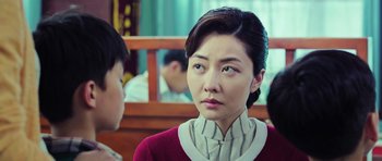 Movie still from “Ip Man 3” (2015), directed by Wilson Yip – A young woman with short black hair wearing a red sweater; Close Up shot, Over the shoulder angle