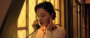 Movie still from “Ip Man 3” (2015), directed by Wilson Yip – A woman talking on a phone while wearing a dress; Close Up shot, Low angle