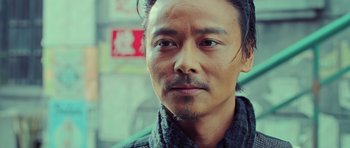 Movie still from “Ip Man 3” (2015), directed by Wilson Yip – A person wearing a sweater; Close Up shot, Low angle