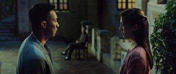 Movie still from “Ip Man 3” (2015), directed by Wilson Yip – A man and a woman are standing in front of a chair; Medium shot, Over the shoulder angle
