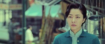 Movie still from “Ip Man 3” (2015), directed by Wilson Yip – A woman in a blue shirt is looking at the camera; Close Up shot, Low angle