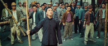 Movie still from “Ip Man 3” (2015), directed by Wilson Yip – A group of men standing in front of a brick wall; Medium shot, High angle