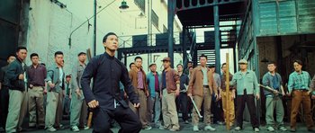 Movie still from “Ip Man 3” (2015), directed by Wilson Yip – A group of men standing next to each other on the street; Wide shot, Low angle