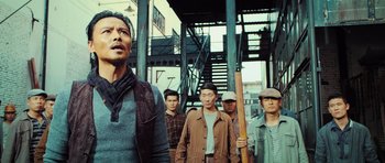 Movie still from “Ip Man 3” (2015), directed by Wilson Yip – A group of men standing next to each other on the street; Medium shot, Low angle