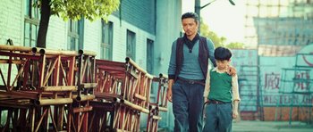 Movie still from “Ip Man 3” (2015), directed by Wilson Yip – A man and a boy walking down a street; Medium shot, Low angle