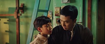 Movie still from “Ip Man 3” (2015), directed by Wilson Yip – A man and a young boy standing next to each other in a room; Close Up shot, Over the shoulder angle