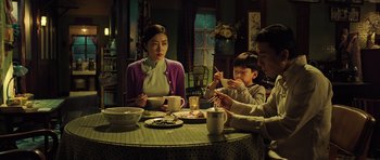 Movie still from “Ip Man 3” (2015), directed by Wilson Yip – Three people sitting at a table eating food; Medium shot, High angle