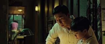 Movie still from “Ip Man 3” (2015), directed by Wilson Yip – A man and a little girl looking at something on a table; Close Up shot, Low angle