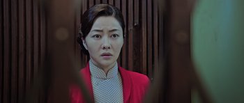 Movie still from “Ip Man 3” (2015), directed by Wilson Yip – A woman in a red jacket is looking at the camera; Close Up shot, Over the shoulder angle