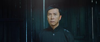 Movie still from “Ip Man 3” (2015), directed by Wilson Yip – A man in a black shirt is looking at the camera; Close Up shot, Low angle