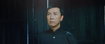 Movie still from “Ip Man 3” (2015), directed by Wilson Yip – A man in a black shirt is looking to his left; Close Up shot, Low angle