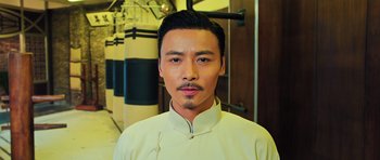 Movie still from “Ip Man 3” (2015), directed by Wilson Yip – A man in a white shirt and a black tie; Close Up shot, Low angle