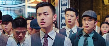 Movie still from “Ip Man 3” (2015), directed by Wilson Yip – A man in a suit and tie standing next to another man; Close Up shot, Over the shoulder angle