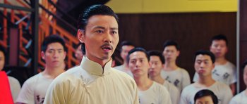 Movie still from “Ip Man 3” (2015), directed by Wilson Yip – A group of men standing next to each other in white shirts; Close Up shot, Over the shoulder angle