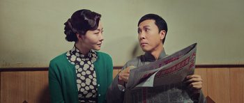 Movie still from “Ip Man 3” (2015), directed by Wilson Yip – A man and a woman looking at each other while holding newspapers; Medium shot, Over the shoulder angle
