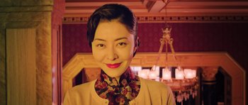 Movie still from “Ip Man 3” (2015), directed by Wilson Yip – A woman in a floral shirt smiling for the camera; Close Up shot, Low angle