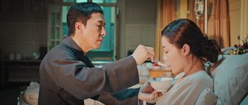 Movie still from “Ip Man 3” (2015), directed by Wilson Yip – A man feeding a woman a bowl of food; Medium shot, Over the shoulder angle