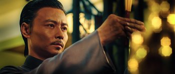 Movie still from “Ip Man 3” (2015), directed by Wilson Yip – A person holding something in his hand; Close Up shot, Low angle