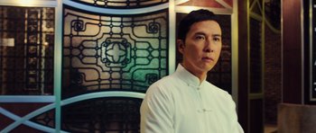 Movie still from “Ip Man 3” (2015), directed by Wilson Yip – A man standing in front of a stained glass window; Close Up shot, Low angle
