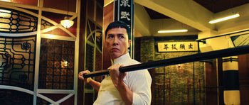 Movie still from “Ip Man 3” (2015), directed by Wilson Yip – A man in a white shirt holding a baseball bat; Medium shot, Low angle