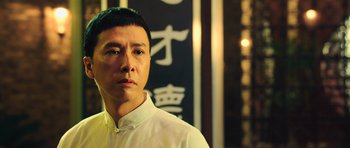 Movie still from “Ip Man 3” (2015), directed by Wilson Yip – A man in white shirt standing in front of a wall; Close Up shot, Low angle