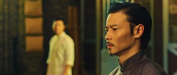 Movie still from “Ip Man 3” (2015), directed by Wilson Yip – A man standing next to another man in a white shirt; Close Up shot, Low angle