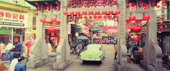 Movie still from “Ip Man 4: The Finale” (2019), directed by Wilson Yip – A car is driving down the street in a foreign city; Extreme Wide shot, High angle