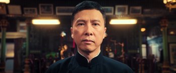 Movie still from “Ip Man 4: The Finale” (2019), directed by Wilson Yip – A person wearing a black shirt; Close Up shot, Low angle