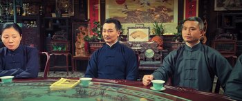 Movie still from “Ip Man 4: The Finale” (2019), directed by Wilson Yip – A man sitting at a table with two cups of tea; Medium shot, Low angle