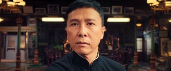 Movie still from “Ip Man 4: The Finale” (2019), directed by Wilson Yip – A person wearing a black shirt; Close Up shot, Low angle