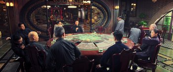Movie still from “Ip Man 4: The Finale” (2019), directed by Wilson Yip – A group of people sitting around a large table; Wide shot, Over the shoulder angle