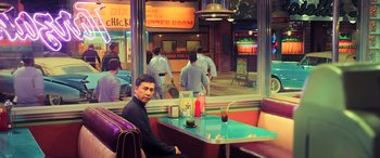Movie still from “Ip Man 4: The Finale” (2019), directed by Wilson Yip – A man sitting at a table in front of a window; Wide shot, High angle