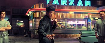 Movie still from “Ip Man 4: The Finale” (2019), directed by Wilson Yip – A young man holding a cell phone up to his ear; Medium shot, Low angle