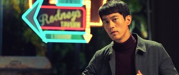 Movie still from “Ip Man 4: The Finale” (2019), directed by Wilson Yip – A man standing in front of a neon sign at night; Close Up shot, Over the shoulder angle