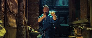 Movie still from “Ip Man 4: The Finale” (2019), directed by Wilson Yip – A man in a blue shirt is practicing martial arts; Medium shot, Low angle