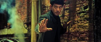 Movie still from “Ip Man 4: The Finale” (2019), directed by Wilson Yip – A man in a black shirt and a black jacket; Medium shot, Low angle