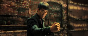 Movie still from “Ip Man 4: The Finale” (2019), directed by Wilson Yip – A man in a black shirt and a brick wall; Medium shot, Low angle