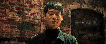 Movie still from “Ip Man 4: The Finale” (2019), directed by Wilson Yip – A man with his eyes closed in front of a brick wall; Close Up shot, Low angle