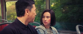 Movie still from “Ip Man 4: The Finale” (2019), directed by Wilson Yip – A man and a woman sitting next to each other on a bus; Close Up shot, Over the shoulder angle