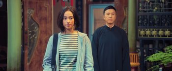 Movie still from “Ip Man 4: The Finale” (2019), directed by Wilson Yip – A man and a woman standing next to each other; Medium shot, Over the shoulder angle