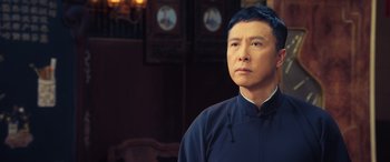 Movie still from “Ip Man 4: The Finale” (2019), directed by Wilson Yip – A man in a blue shirt is looking at the camera; Close Up shot, Low angle