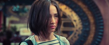 Movie still from “Ip Man 4: The Finale” (2019), directed by Wilson Yip – A young woman with short brown hair wearing a striped shirt; Close Up shot, Over the shoulder angle