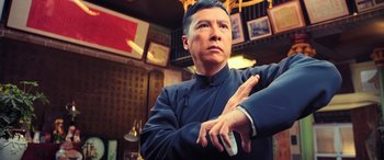 Movie still from “Ip Man 4: The Finale” (2019), directed by Wilson Yip – A man standing in a room with his arms crossed; Medium shot, Low angle