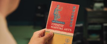 Movie still from “Ip Man 4: The Finale” (2019), directed by Wilson Yip – A hand is holding an old book with a picture on it; Extreme Close Up shot, High angle