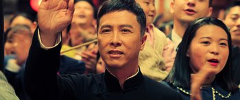 Movie still from “Ip Man 4: The Finale” (2019), directed by Wilson Yip – A person with a crowd of people; Close Up shot, Low angle