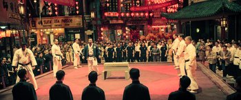 Movie still from “Ip Man 4: The Finale” (2019), directed by Wilson Yip – A group of people standing in front of an audience; Extreme Wide shot, High angle