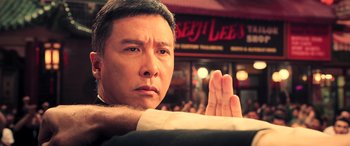 Movie still from “Ip Man 4: The Finale” (2019), directed by Wilson Yip – A person holding their hand up; Close Up shot, Over the shoulder angle